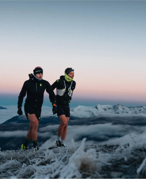 Photographie de deux hommes en train de faire une randonnée en montagne sous la neige
